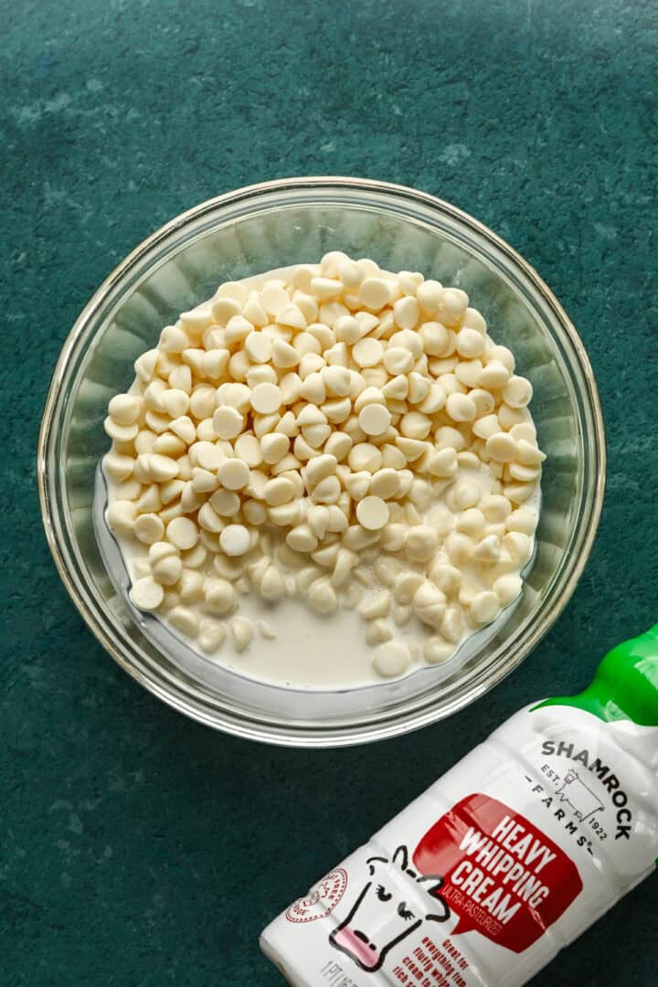 Vit choklad och tung grädde i en skål.