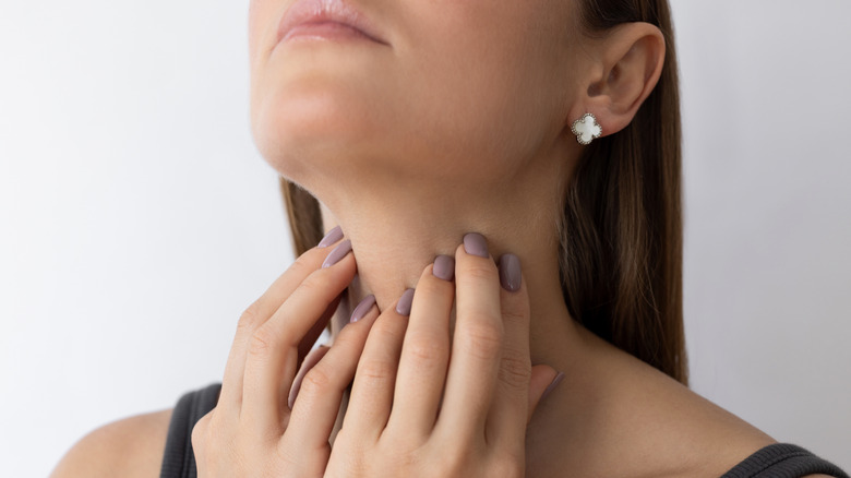 kvinna vidrör platsen för sköldkörteln