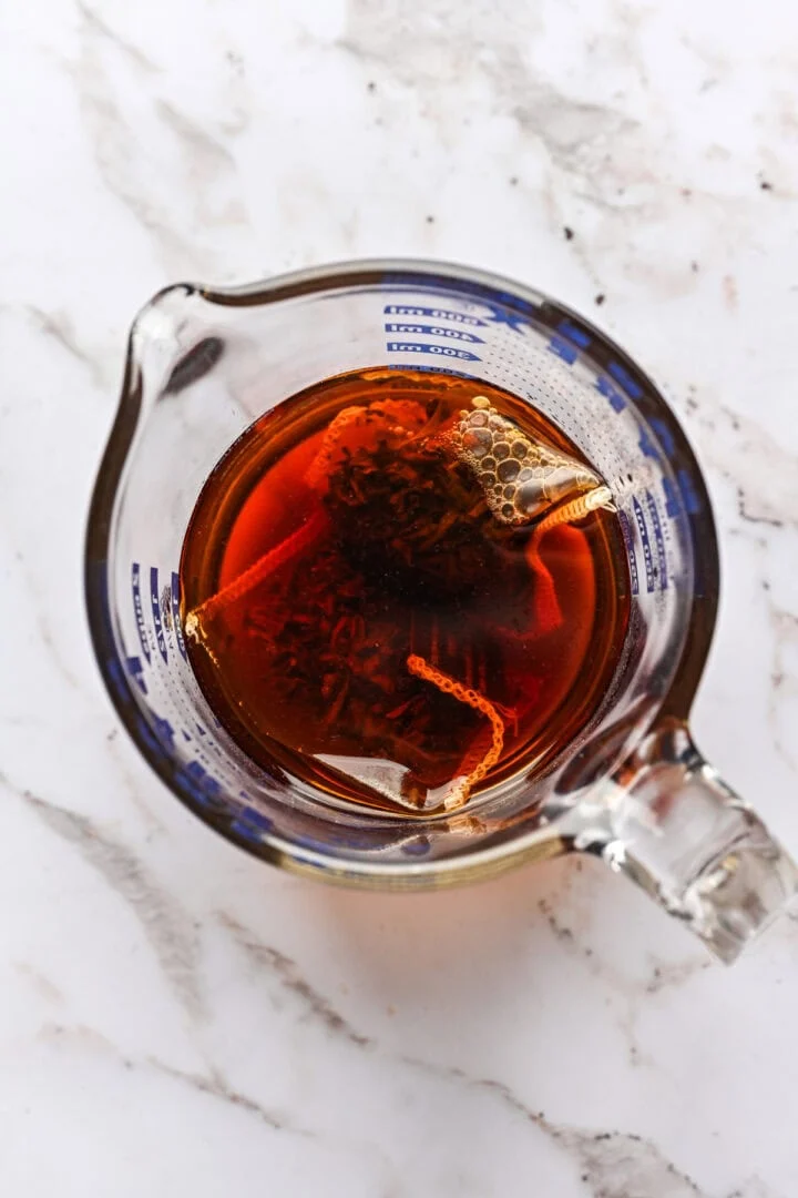 ovanifrån av earl grey te som drar i en måttkopp.