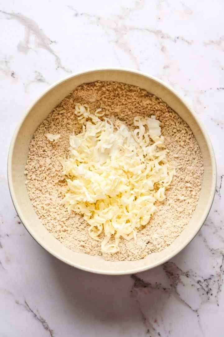 Fikonpudding torra ingredienser toppad med rivet fryst smör och matfett.