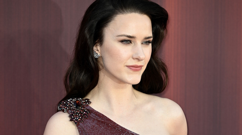 Rachel Brosnahan i en enaxelklänning och tittar åt sidan.