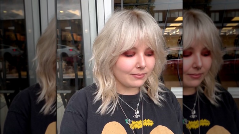 En kvinna med en blond shag och gardin lugg