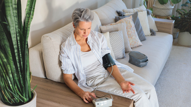 äldre kvinna som kontrollerar blodtrycket