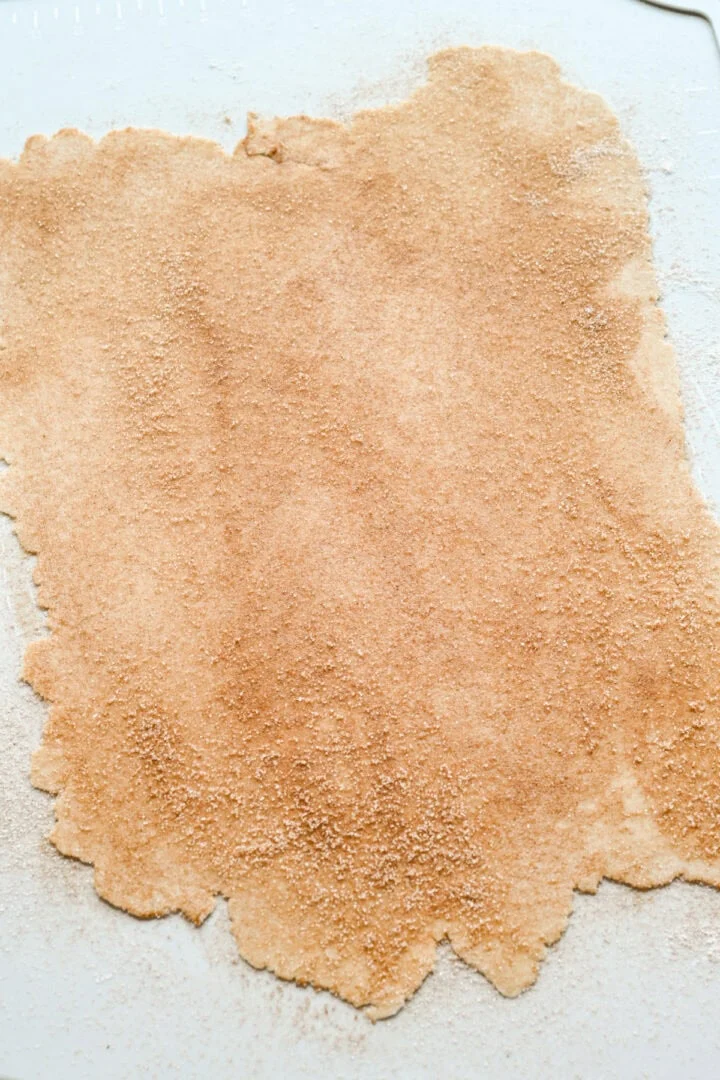 Degen kavlas ut till ett tunt ark och strös över kanelsocker.