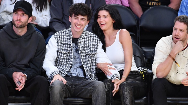 Timothée Chalamet och Kylie Jenner skrattar i folkmassan på ett sportevenemang