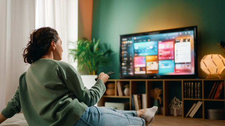 kvinna hemma bestämmer vad hon ska titta på på en TV-streamingtjänst