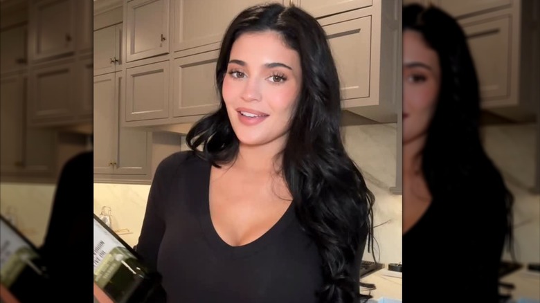 Kylie Jenner med en sminkfri look med en flaska Smash Oil