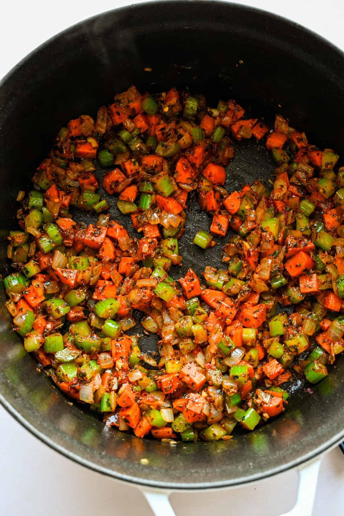 Tomatpuré och kryddor tillsatt grönsakerna i grytan.
