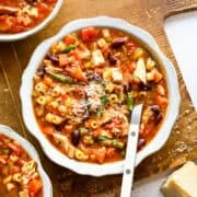 Kyckling minestronesoppa i en vit skål med en sked.