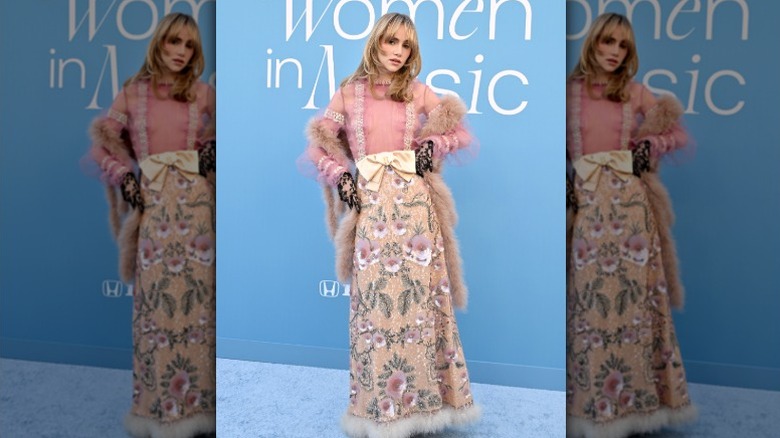 Suki Waterhouse poserar på den blå mattan på en prisutdelning