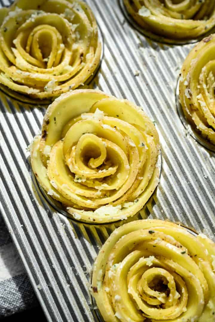 Vy ovanifrån av potatisrosa i en muffinsplåt innan gräddning.