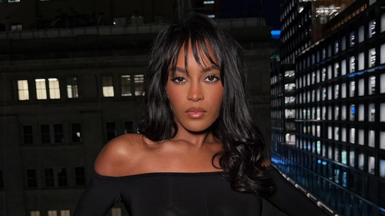 Ciara Miller poserar med lockigt hår och strålig lugg