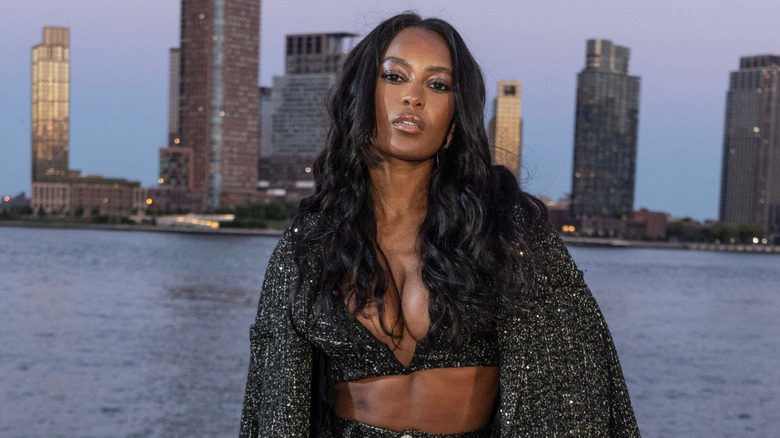 Ciara Miller poserar med lockigt hår framför Hudson River