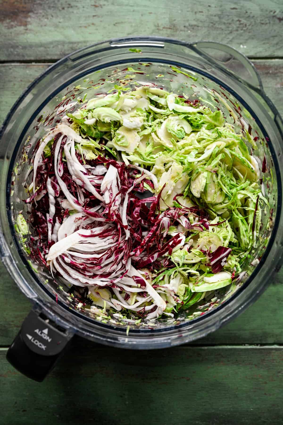Brysselkål, radicchio och broccolistjälkar skivade i en matberedare.
