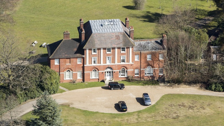 En bild av Forest Lodge, Kate Middleton och prins Williams nya hem. Det är ett stort tegelhus med många fönster, omgivet av frodigt grönt.