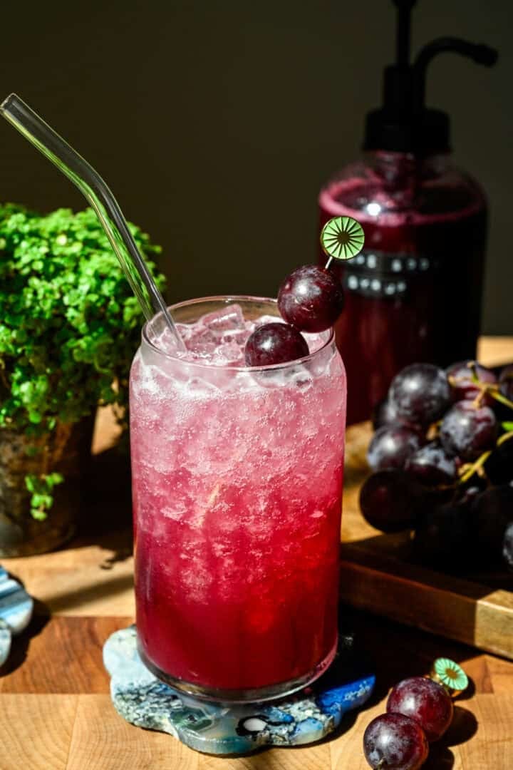 Framifrån av druvläsk i ett glas.