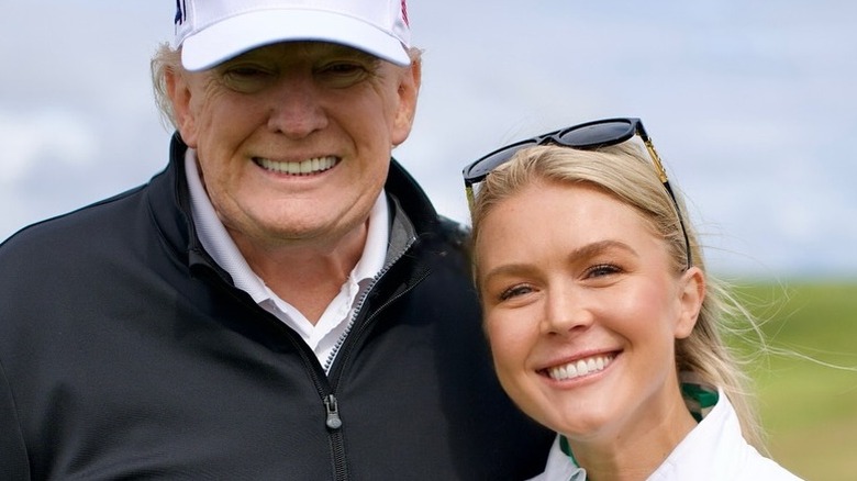 Donald Trump och Karoline Leavitt poserar på en golfbana i Skottland