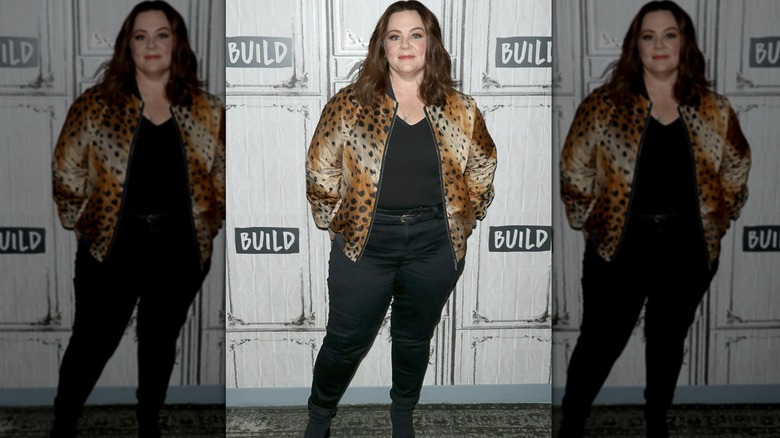 Melissa McCarthy ler medan hon bär en leopardmönstrad kappa