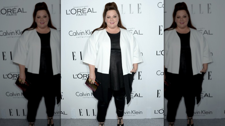 Melissa McCarthy ler i vit kavaj och svart topp med jeans