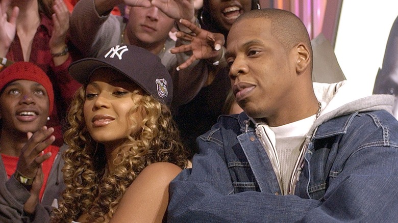 En återgångsbild av Jay-Z och Beyonce. De är båda cirka 15-20 år yngre och poserar axel mot axel med armarna i kors.