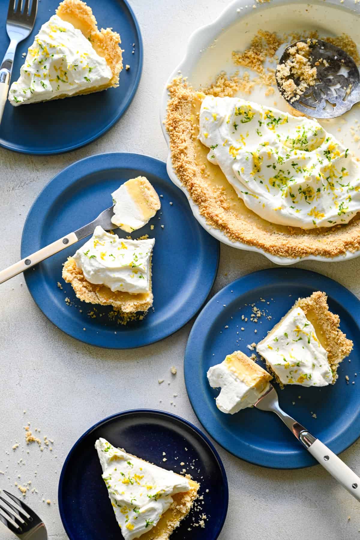 Vy ovanifrån av flera skivor av atlantic beach paj på blå tallrikar bredvid hela pajen.