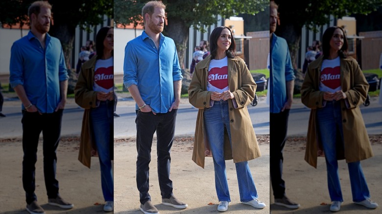 Meghan Markle på bilden med prins Harry klädd i en grafisk t-shirt, jeans och en trenchcoat