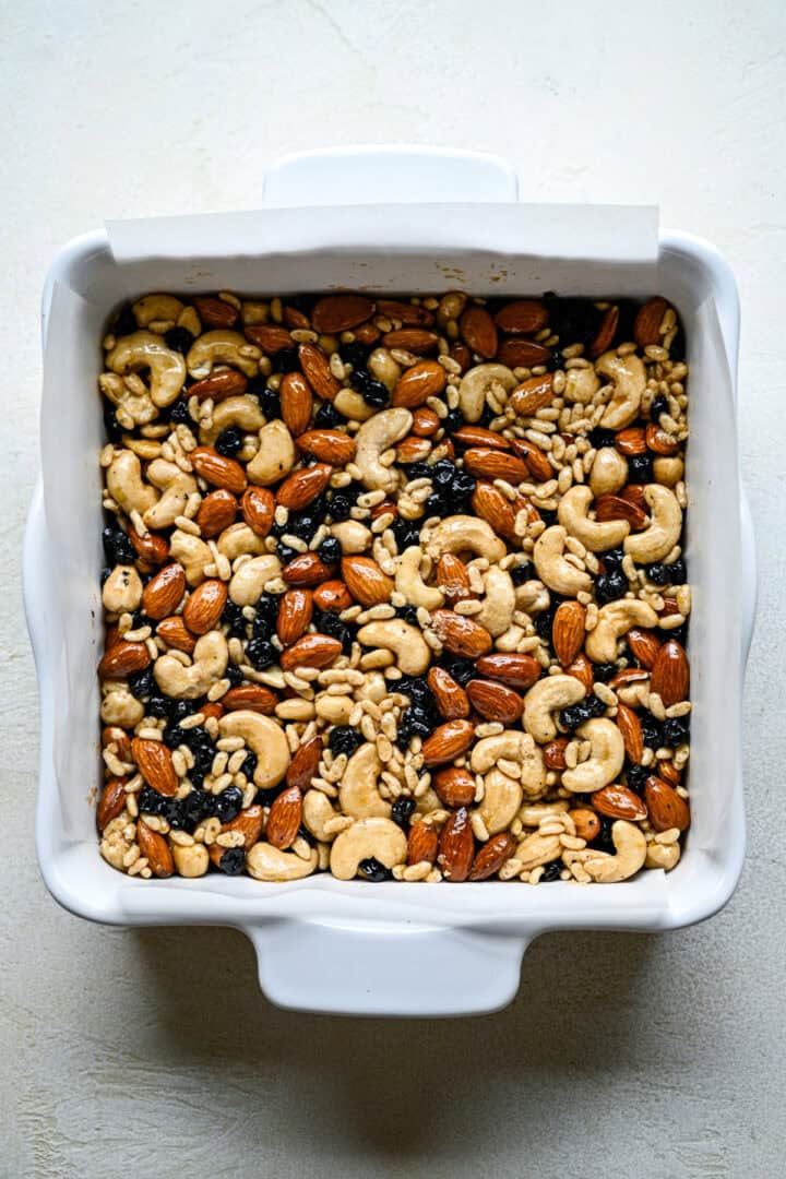 Ovanifrån av blåbär cashew snackbarer i panna innan bakning.