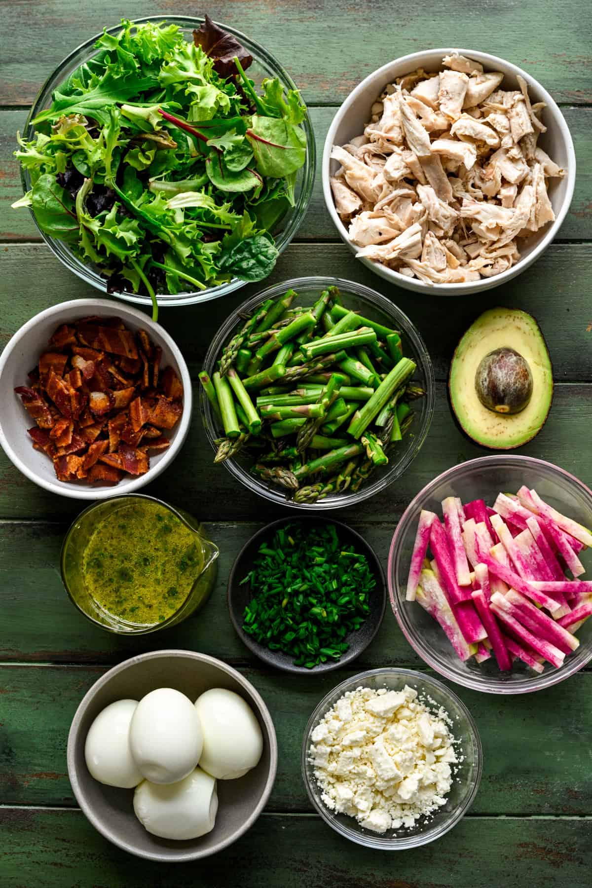 Ovanifrån av ingredienser som går i våren cobb sallad i små förberedelser skålar.