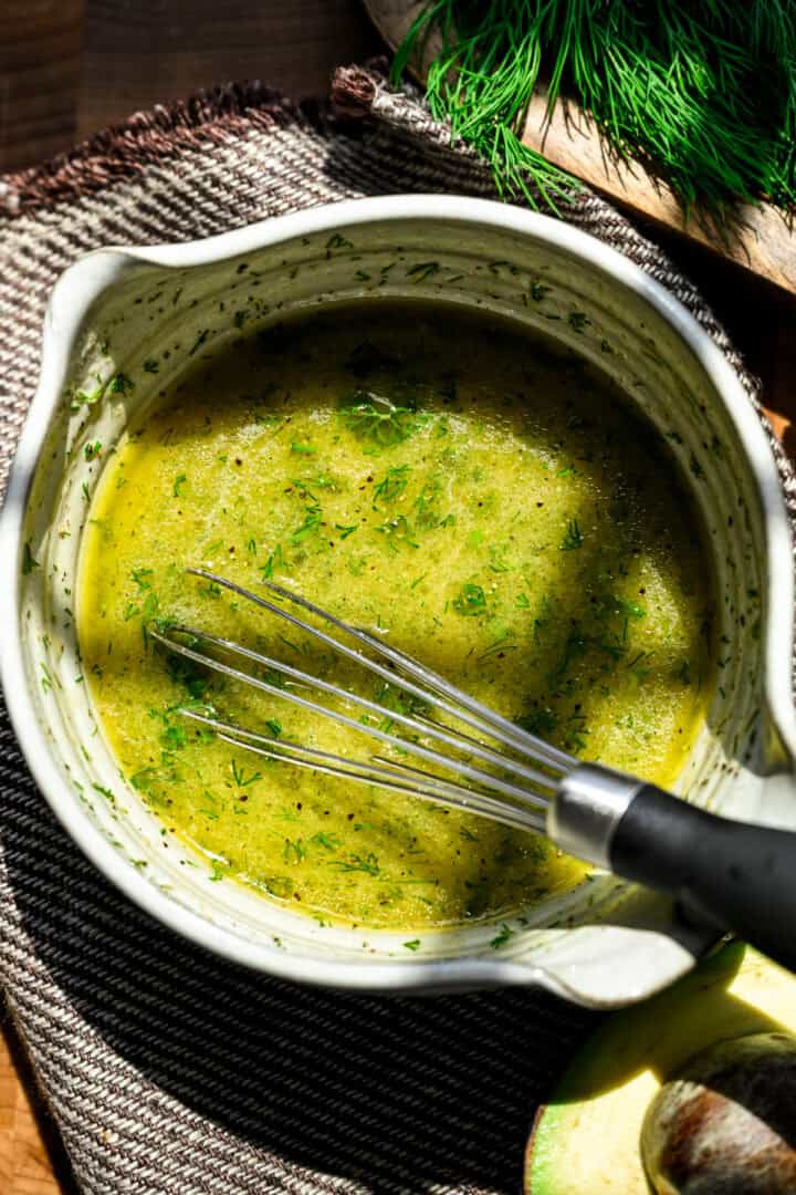 Ingredienser för citrondilldressing i en skål efter vispning.