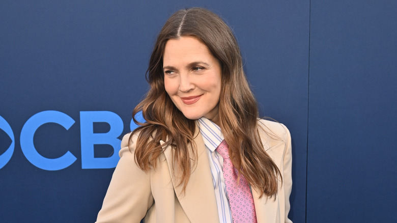 Drew Barrymore ler och poserar vid en offentlig tillställning efter att ha anammat nykterhet