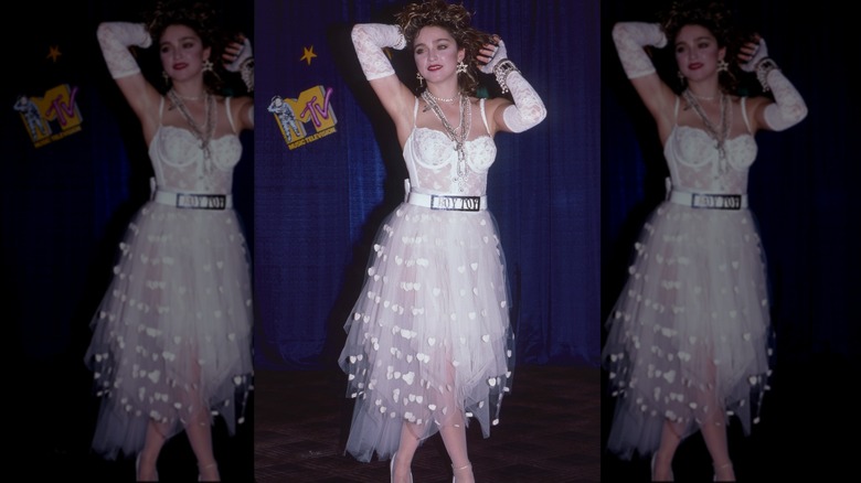 Madonna bär en vit spets outfit och 