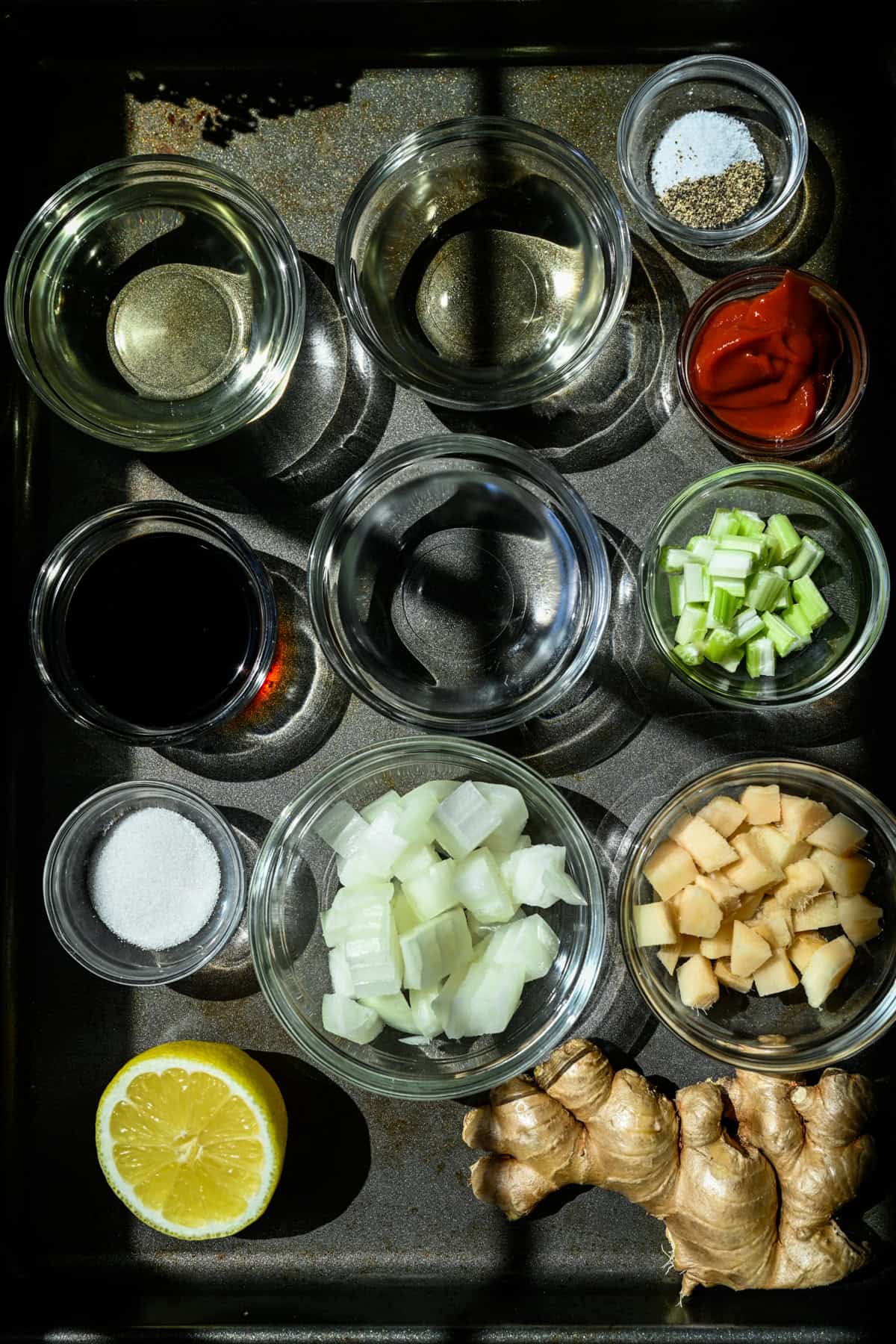 Ovanifrån av ingredienser för hemlagad ingefäradressing i små skålar.