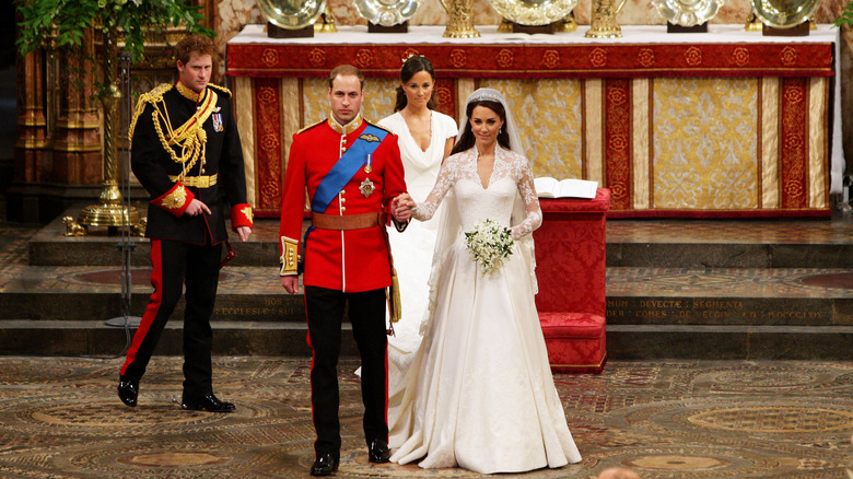 Kate Middleton i sin bröllopsklänning håller hand med prins William när de förbereder sig för att lämna