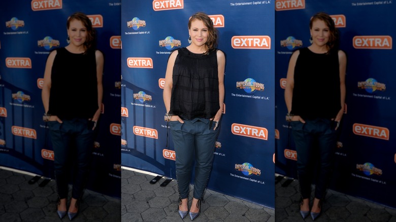 Alyssa Milano bär en flytande topp och smala byxor när hon är gravid