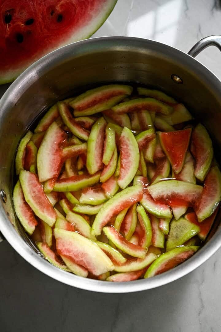 Vattenmelonskal läggs i en gryta.
