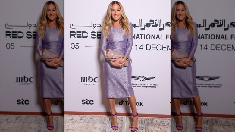 Sarah Jessica Parker poserar på ett evenemang i en långärmad lilafärgad klänning 2024.