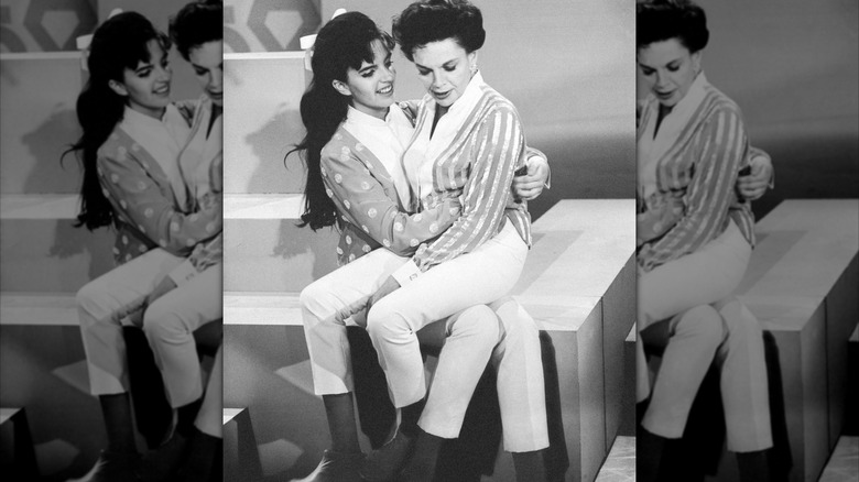 Svartvitt foto av Liza Minnelli bredvid sin mamma Judy Garland på en uppsättning.