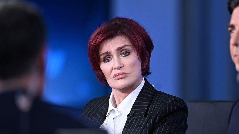 Sharon Osbourne sitter vid ett skrivbord under en panelintervju