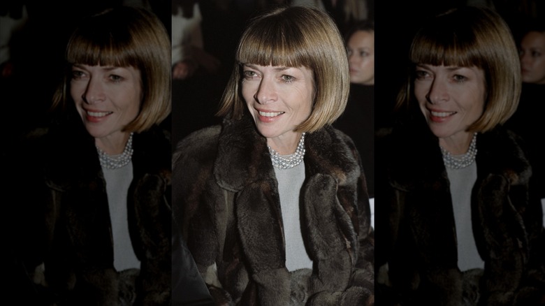 Anna Wintour ler med honungsblont hår iklädd pälsjacka och pärlhalsband
