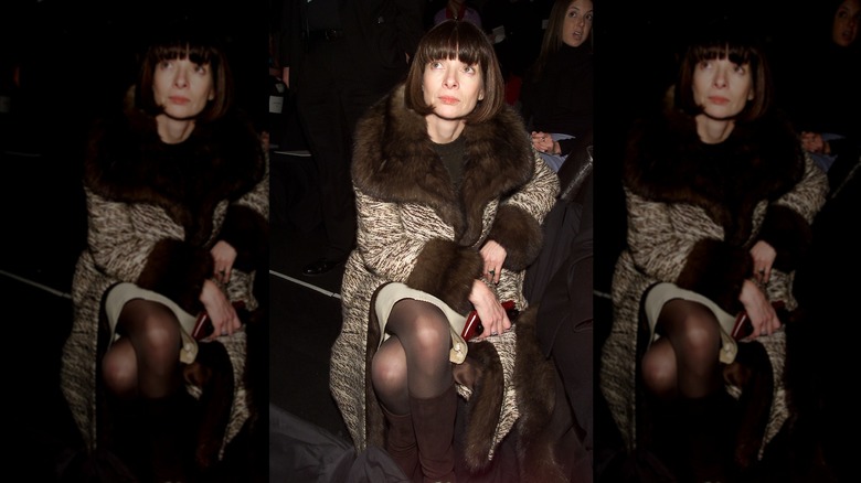 Anna Wintour tittar upp med mörkbrunt hår iklädd en pälskantad jacka