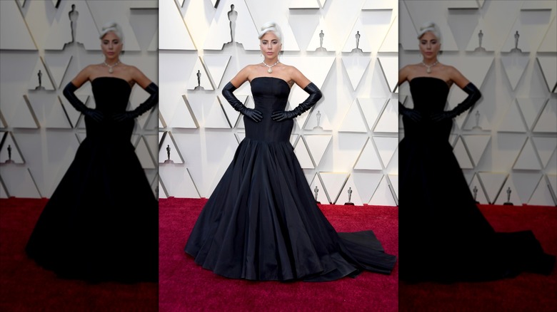 Lady Gaga poserar med händerna på höfterna iförd svarta handskar