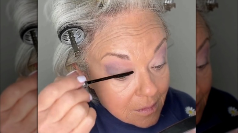 Mogen kvinna som applicerar mascara