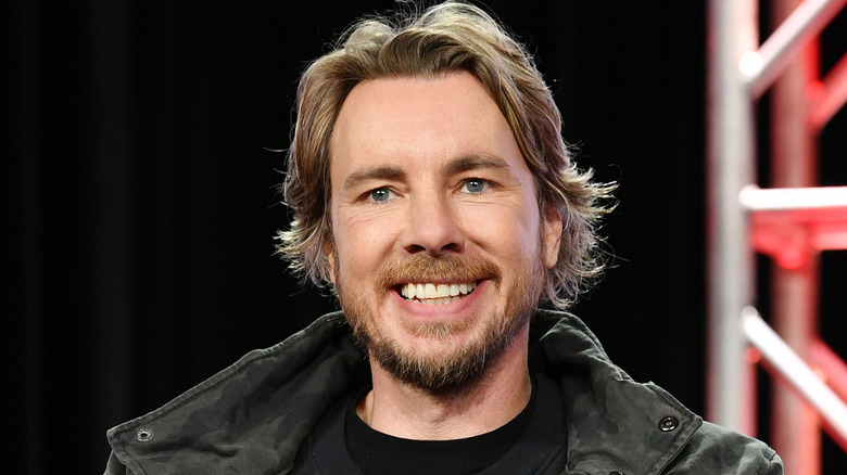 Dax Shepard ger ett stort leende till en publik vid ett evenemang