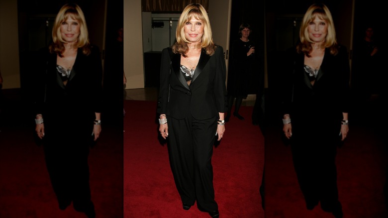 Nancy Sinatra på ett event på röda mattan klädd i en helsvart outfit med håret neråt.