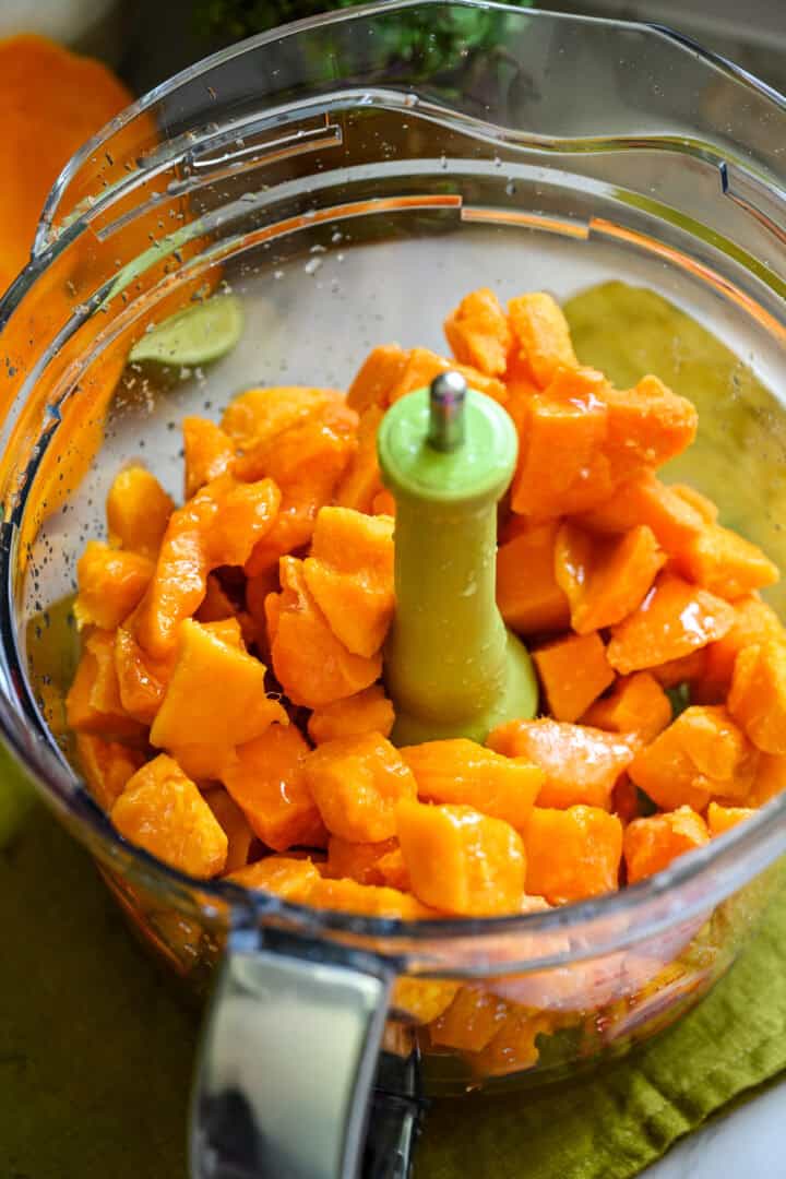 Ingredienser till mangosorbet i en matberedare innan du mixar.