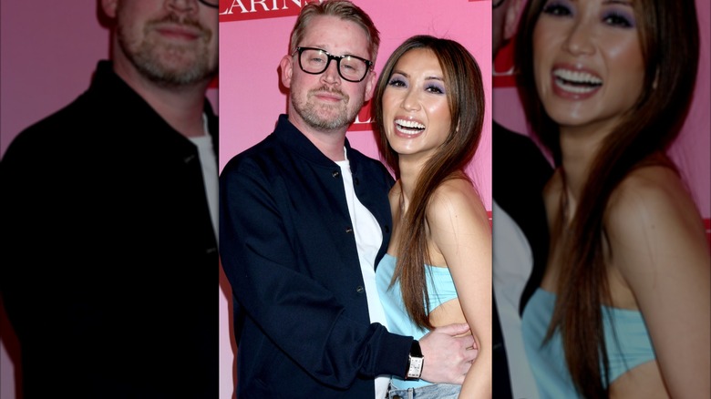 Macaulay Culkin i en marinblå button down stående bredvid Brenda Song i en turkos tubtopp.