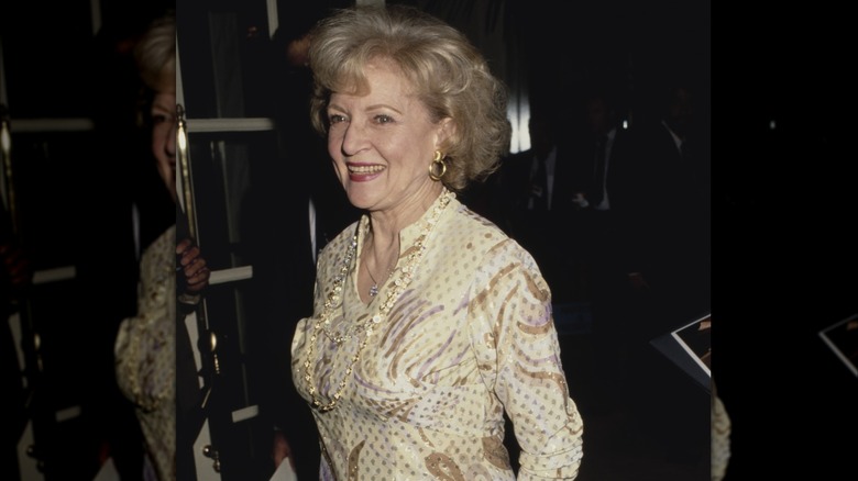 Den amerikanska skådespelerskan och komikern Betty White, iklädd klänning med gult tryck, ler när hon deltar i 5th Annual Genesis Awards, som delas ut av Humane Society of the United States (HSUS) för att öka allmänhetens medvetenhet om djurrättsfrågor, som hålls på Beverly Wilshire Hotel i Beverly Hills, Kalifornien, 3 februari 1991