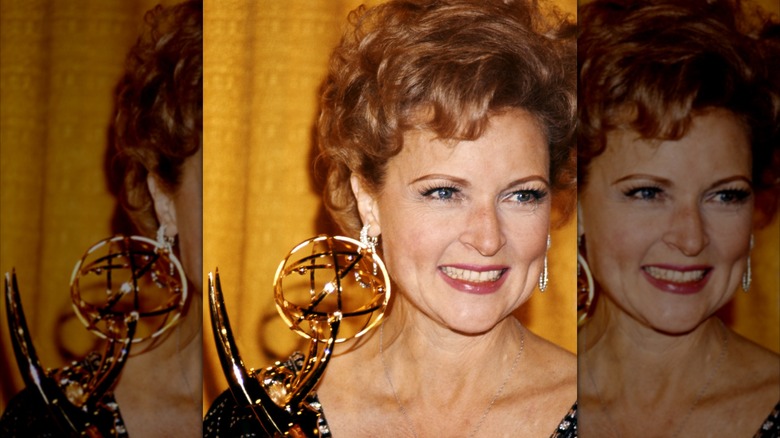 Betty White, amerikansk skådespelerska, ler när hon har en Emmy Award, mot en gul bakgrund, USA, cirka 1975
