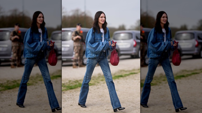 En kvinna som går i bootcut-jeans och en överdimensionerad jeansjacka