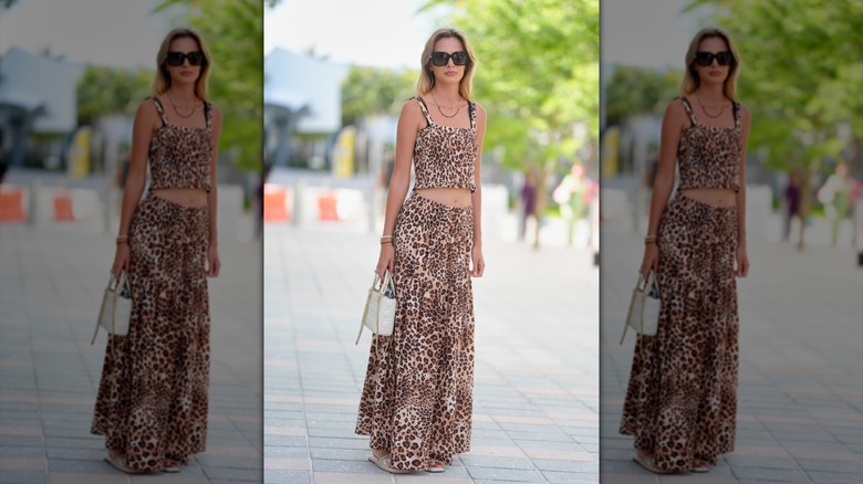 En kvinna som bär en leopard i två delar med solglasögon